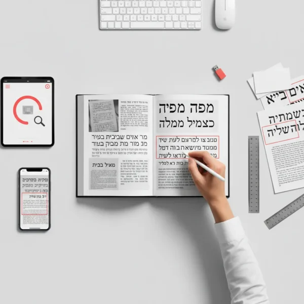 תמונה מלמעלה של שולחן עבודה עם מחשב, טאבלט, טלפון, ספר פתוח, עט, סרגל וניירות עם טקסט בעברית.